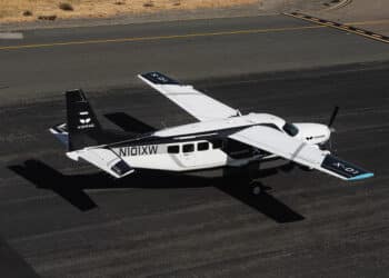an Xwing Cessna 208B sits on the ramp of an airport