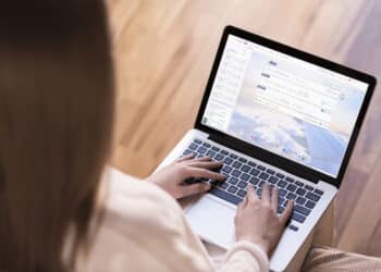 A woman types on a laptop with CargoAi's CargoMart on the screen