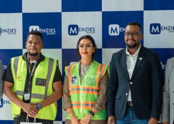 Five people stand before a Menzies Aviation sign