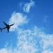 Silhouette of a plane against a blue sky