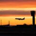 A plane lands at Copenhagen Airport as the sun sets