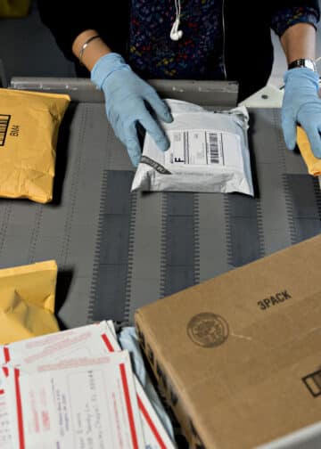 A worker sorts packages at the U.S. Postal Service processing and distribution center in Merrifield, Va. (Courtesy/Andrew Harrer/Bloomberg)