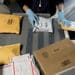 A worker sorts packages at the U.S. Postal Service processing and distribution center in Merrifield, Va. (Courtesy/Andrew Harrer/Bloomberg)