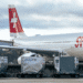ULDs on the tarmac in front of a Swiss plane