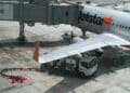 A refueling truck alongside a Jetstar plane at Singapore Changi Airport