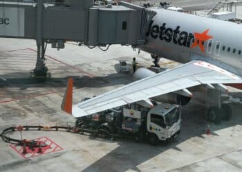 A refueling truck alongside a Jetstar plane at Singapore Changi Airport