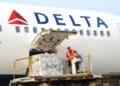 ramp agent handles cargo into a Delta aircraft