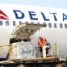 ramp agent handles cargo into a Delta aircraft