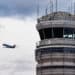 a plane takes off near an air traffic control tower