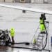 Ground operations employees fuel a plane on the tarmac at Denver International Airport. (Courtesy/Bloomberg)