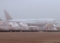 An Air Canada Cargo freighter in the mist with cargo pallets in front of it